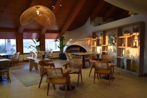 un restaurante con mesas y sillas y una chimenea en Hotel Marbella Resort, en Maitencillo