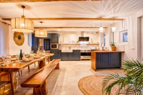 une grande cuisine avec des tables en bois et une salle à manger dans l'établissement Maison Adeli - SPA- Braséro-Billard- Netflix-Wifi, à Dozulé