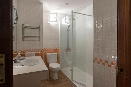 uma casa de banho com um WC, um chuveiro e um lavatório. em Casita Coqueta Free Parking em Cádiz