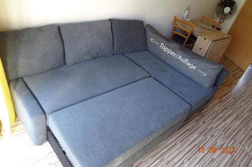 a blue couch sitting in a living room at Ferien im Sauerland ( barrierefreie Wohnung ) in Plettenberg