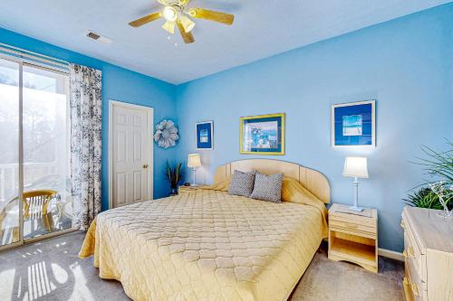 a bedroom with a bed with blue walls and a ceiling fan at Golfers Paradise in Myrtle Beach