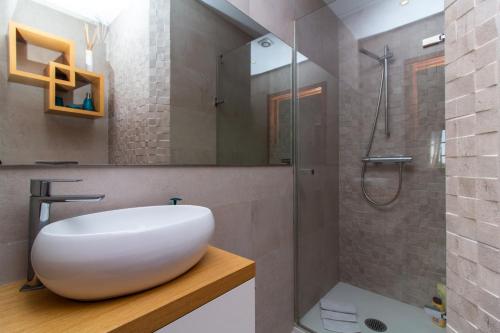 uma casa de banho com um lavatório branco e um chuveiro em Villa a Sul em Albufeira