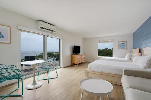 a bedroom with a bed and a couch and a table at Fisher Inn Resort & Marina in Islamorada