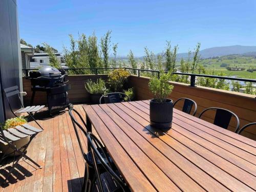a wooden table on a balcony with a grill at Gerringong Bliss in Gerringong