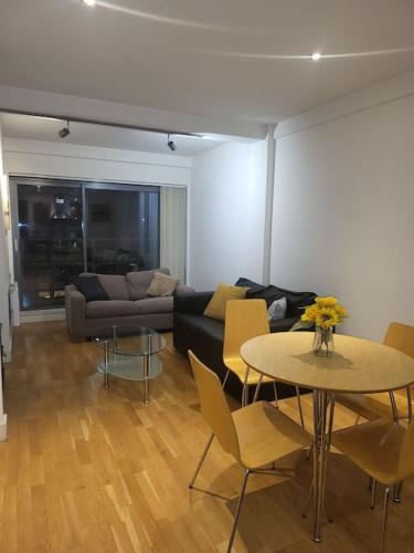 a living room with a table and a couch at Striking 1 bedroom apartment in Manchester