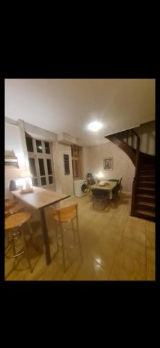 un salon avec une table et des chaises et un escalier dans l'établissement Maison chaleureuse à 20mn de saint Amand Montrond., à Le Châtelet