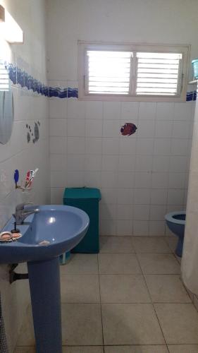 La salle de bains est pourvue d'un lavabo bleu et de toilettes. dans l'établissement JOYAUX DE TIVOLI VILLA, à Fort-de-France
