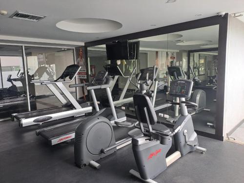 a gym with several tread machines and a mirror at QUO 704 APARTAMENTO in Guayaquil