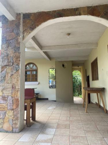 un corridoio aperto con un muro in pietra e un tavolo di Hotel Xucaneb a Cobán