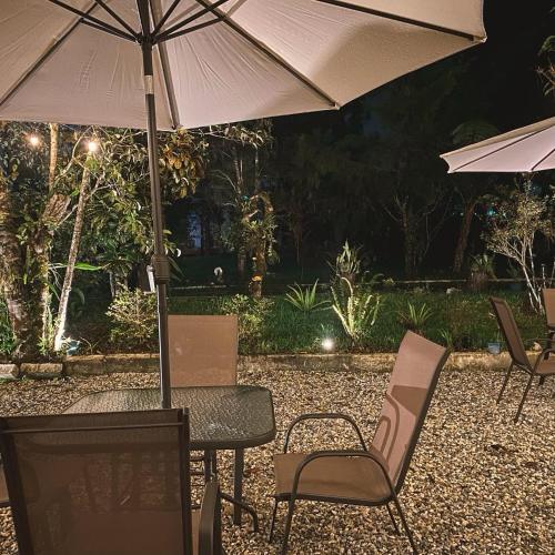 - une table et des chaises avec un parasol sur la terrasse dans l'établissement Hotel Xucaneb, à Cobán