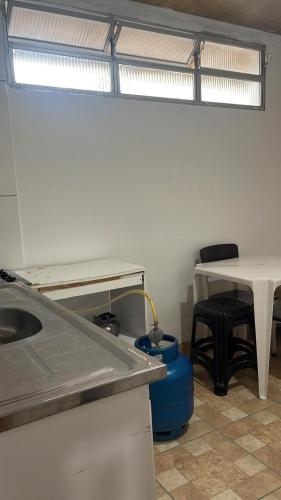 eine Küche mit einem Waschbecken, einem Tisch und einem Schreibtisch in der Unterkunft Kitnet na 262 in Itapema