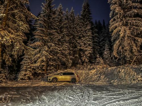 a car driving down a snow covered road with trees at Vila Bašić Vlašić Apartman MEDO in Vlasic