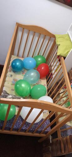 - un lit bébé en bois avec des balles de couleur différente dans l'établissement Relax time Vidéken, à Kiskunhalas