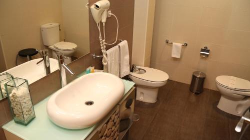 a bathroom with a sink and a toilet at Hotel Macami in El Carpio