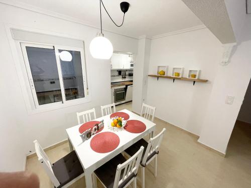 cocina y comedor con mesa blanca y sillas en Villa Dulce, en Gran Alacant