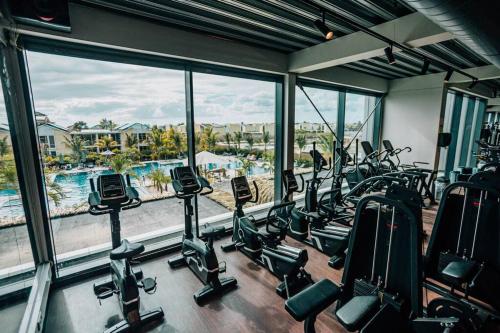 a gym with a bunch of treadmills and ellipticals at Villa Kiwi 3 min to the Beach with Private Magnesium Pool in Belnem