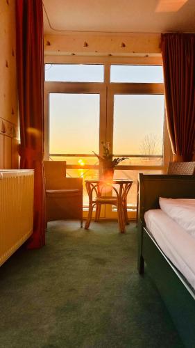 a room with a bed and a table and a window at Gästehaus Weserblick am Weser-Sandstrand in Berne