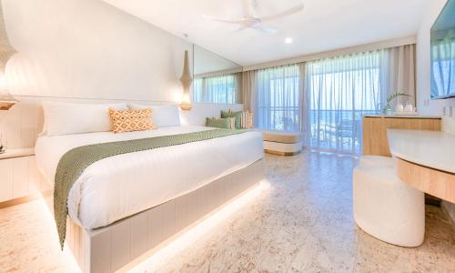 a bedroom with a large bed and a desk at The Elandra in South Mission Beach