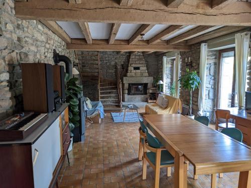 Il dispose d'une cuisine et d'un salon avec une table et une cheminée. dans l'établissement TY MAEN - Authentique moulin du 18ème proche mer, à Plourin