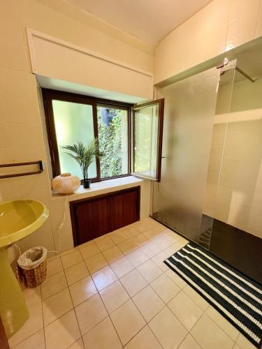 La salle de bains est pourvue d'une douche et d'une fenêtre. dans l'établissement TY MAEN - Authentique moulin du 18ème proche mer, à Plourin