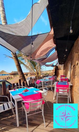 a group of tables with chairs and umbrellas on a deck at Hotel & Apartments "CHEZ HIVA" in Hanga Roa