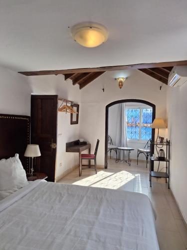 a bedroom with a bed and a table and chairs at Dar Gabriel in Chefchaouene