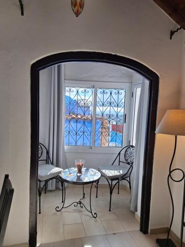 a room with a table and chairs and a window at Dar Gabriel in Chefchaouen
