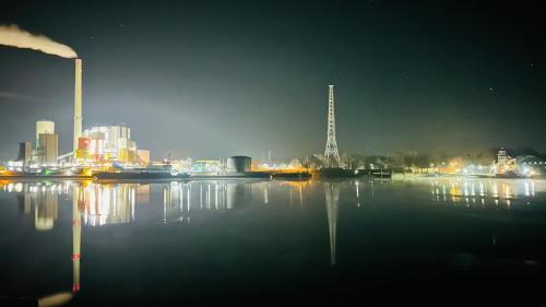 a view of a city at night from the water at Gästehaus Weserblick am Weser-Sandstrand in Berne