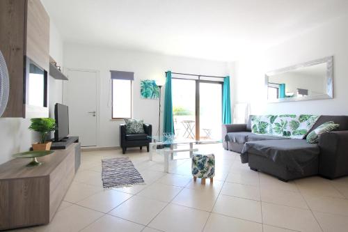 un soggiorno con divano e tavolo di Appartement avec piscine - Albufeira ad Albufeira