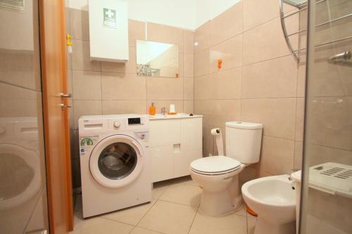 łazienka z pralką i toaletą w obiekcie Appartement avec piscine - Albufeira w Albufeirze