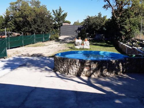 two people sitting in chairs next to a swimming pool at La Huerta de Elisa in Villanueva de Duero