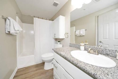 Baño blanco con lavabo y aseo en Mid Century Style / King Bed / Disneyland / Nurses en Santa Ana