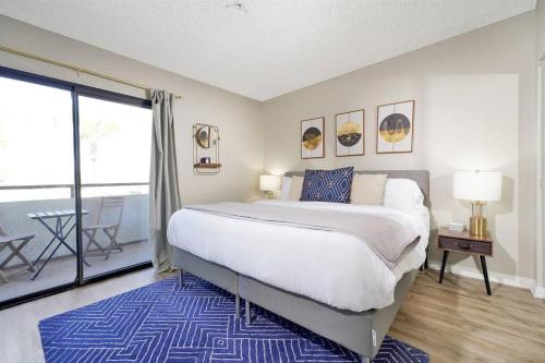 1 dormitorio con 1 cama grande y balcón en Mid Century Style / King Bed / Disneyland / Nurses en Santa Ana