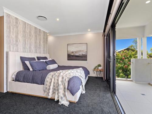 1 dormitorio con cama y ventana grande en Koala Vista with Panoramic Views & Pool, en Pottsville