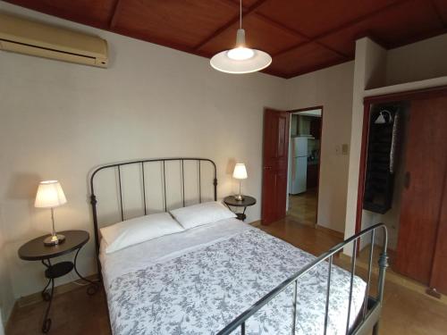 sypialnia z łóżkiem z dwoma stołami i dwoma lampami w obiekcie Villa Gascue Guest Apartments w mieście Santo Domingo