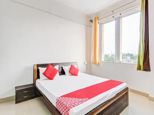 a bedroom with a bed with red pillows and a window at Collection O Sangam Hotel in Chirāwa