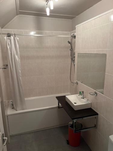 a bathroom with a sink and a tub and a shower at The Anderson in Fortrose