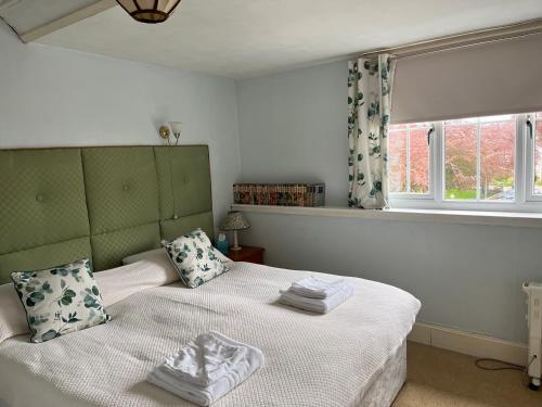 a bedroom with a bed with white sheets and a window at The Anderson in Fortrose