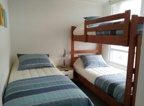 a bedroom with two bunk beds and a window at Departamento playa La Herradura in Coquimbo