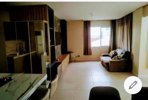 a hotel room with a couch and a window at Apartamento Amplo e Moderno 300m da Praia 2 camas de casal 1 cama de solteiro AR CONDICIONADO nos quartos in Piçarras