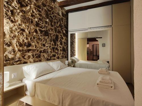 Schlafzimmer mit einem großen weißen Bett und einem Spiegel in der Unterkunft Old Town Apartment in Alghero