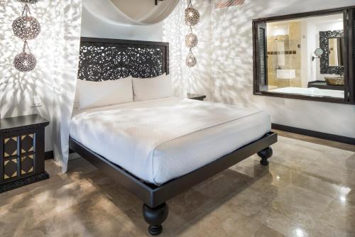a bedroom with a bed and a large mirror at Hilton Vacation Club Cabo Azul Los Cabos in San José del Cabo