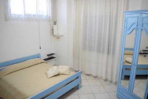 1 dormitorio con cama azul y espejo en B&B Il Sole, en Torre Annunziata