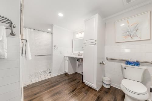 a white bathroom with a toilet and a shower at Old Colorado Inn in Stuart