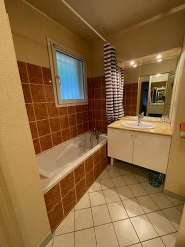 une salle de bain avec une baignoire et un lavabo dans l'établissement Super appartement en résidence proche du centre, à Briançon