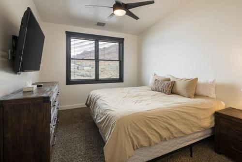 a bedroom with a bed and a flat screen tv at Luxury Downtown Rental - La Dolce Vita Villa #4 in Moab