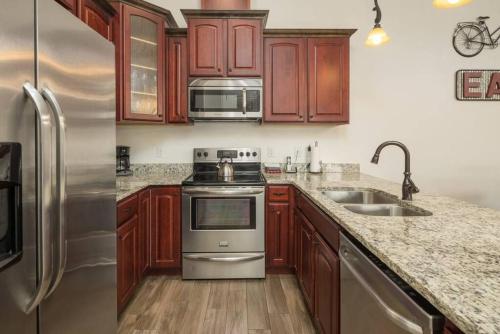 una cocina con armarios de madera y electrodomésticos de acero inoxidable en Luxury Downtown Rental - La Dolce Vita Villa #4, en Moab