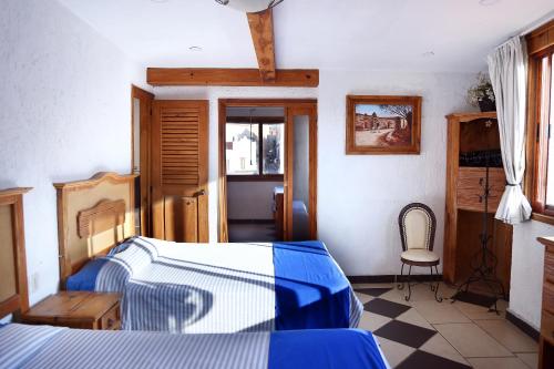 a bedroom with a bed and a table and a chair at Meson de Juan Valle in Guanajuato
