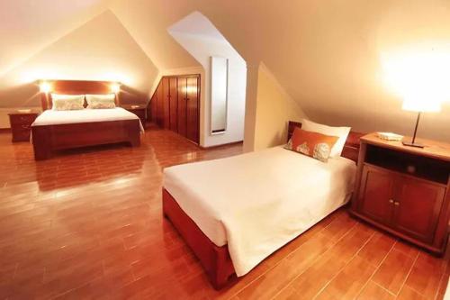 a large bedroom with two beds and a lamp at Pico Alto in Salão