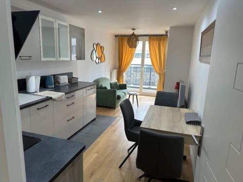 une cuisine et un salon avec une table et des chaises dans l'établissement Appartement Neuf de 40 M2 à Issy-Les-Mx / Paris 15, à Issy-les-Moulineaux